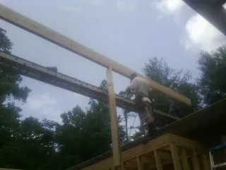 Carpenter setting a ridge beam over a new addition frame — Ice Dam Removal by Roofing Brothers in Grovertown