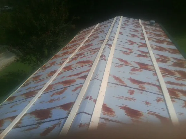 Rusted metal roof panels with new wood purlins before replacement — Storm Damage Roof Repair in Grovertown by Roofing Brothers