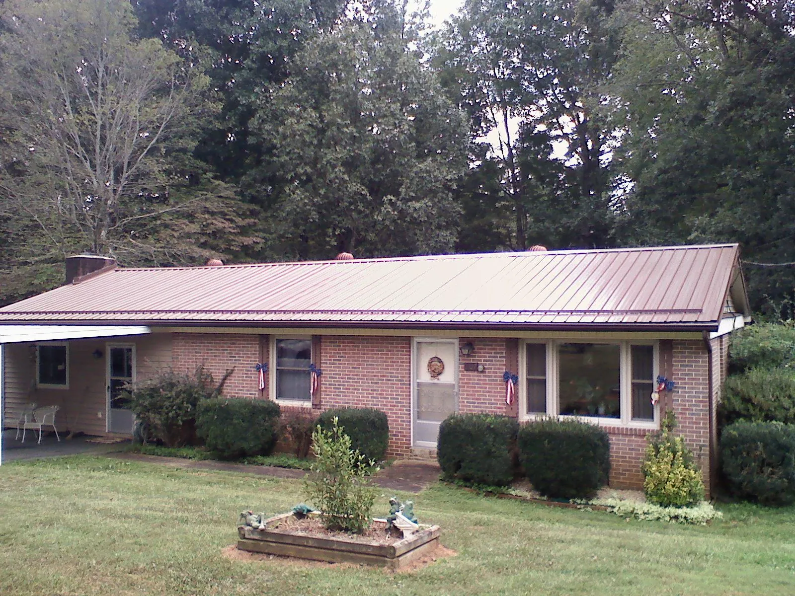 Bronze metal roof on a brick ranch home with a carport in Grovertown