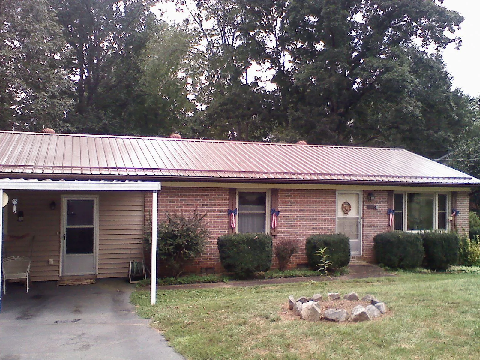Bronze metal roof and carport on a brick ranch home — Roof Repair work by our crew in Grovertown